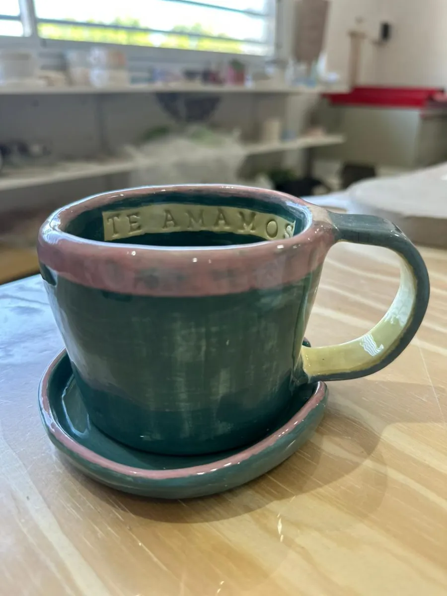 Taza y plato de cerámica esmaltada en verde, con la inscripción "Te amamos"