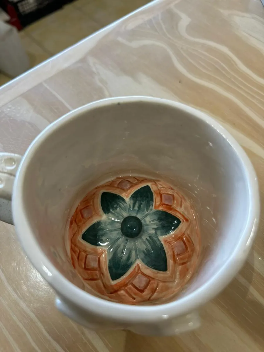 Bowl de cerámica blanca con una flor en relieve en el fondo