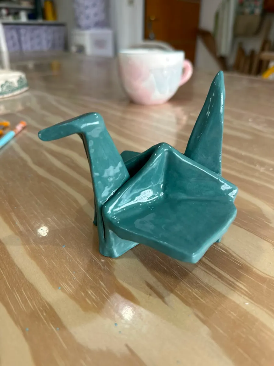 Grulla de papel plegado hecha en cerámica turquesa