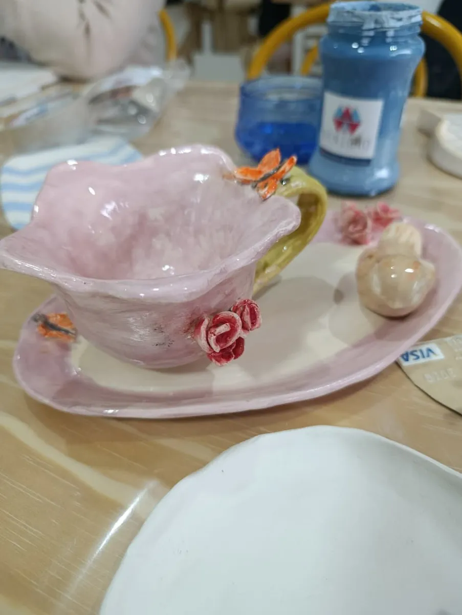 Taza y plato de cerámica rosa con flores en relieve