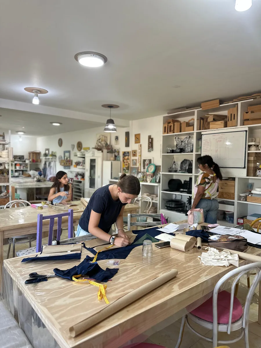 La mesa de trabajo del taller de costura, con moldes, telas y alfileres