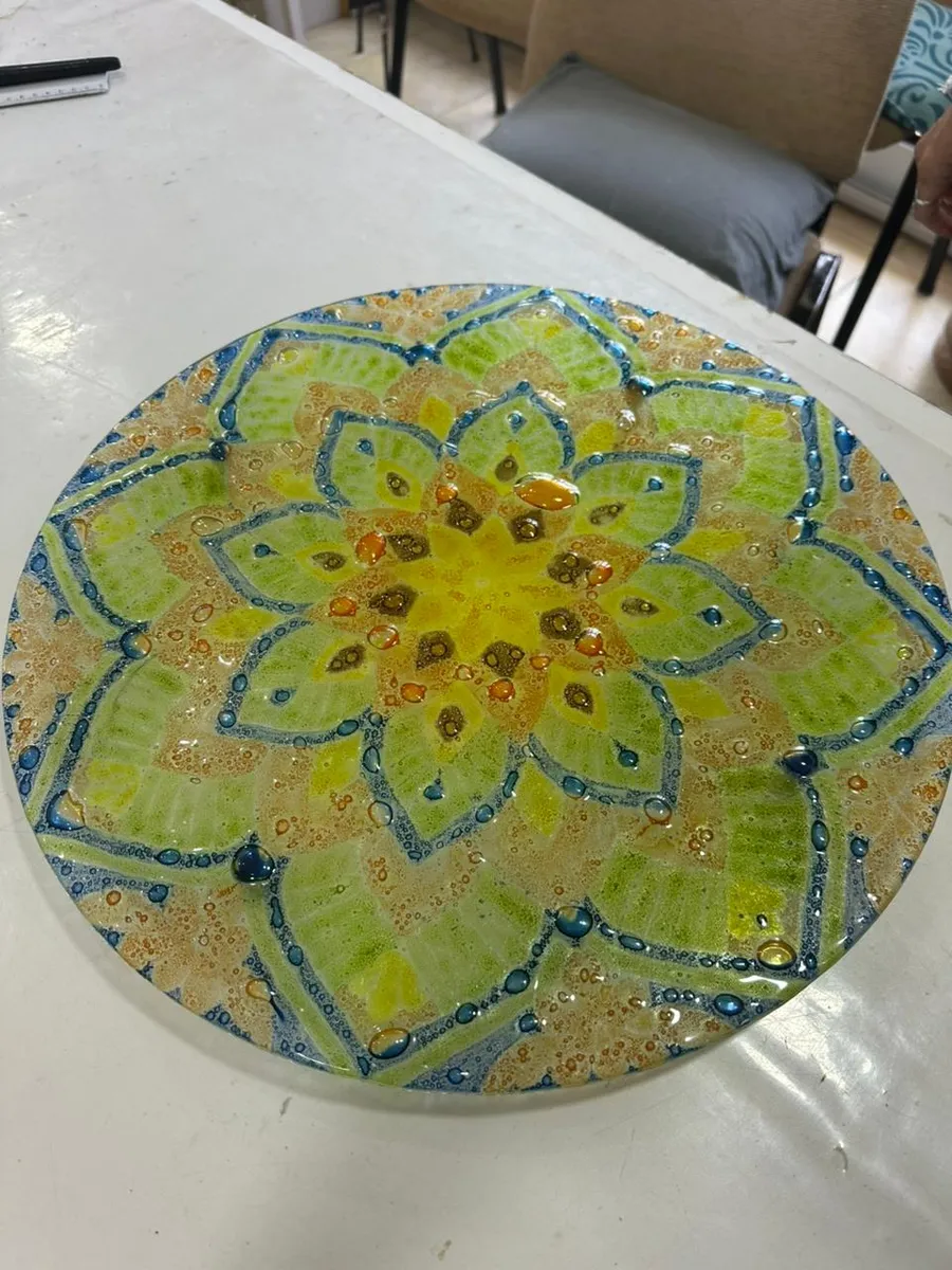 Plato de vitrofusión con una flor verde y dorada