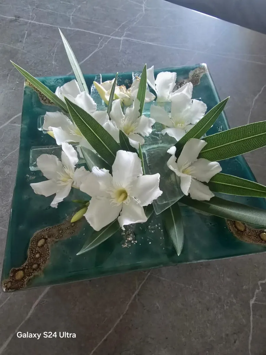 Bandeja cuadrada de vitrofusión verde con flores blancas encima