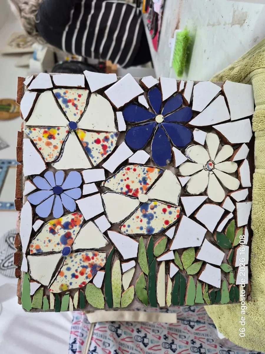 Panel de mosaico con flores azules y violetas sobre fondo blanco